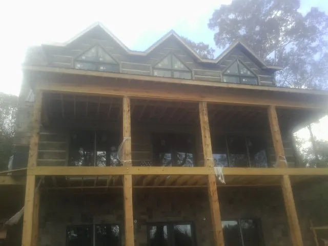 Dormers and porch framing on a large log home under construction — Roof Coating work by our crew in Marlinton