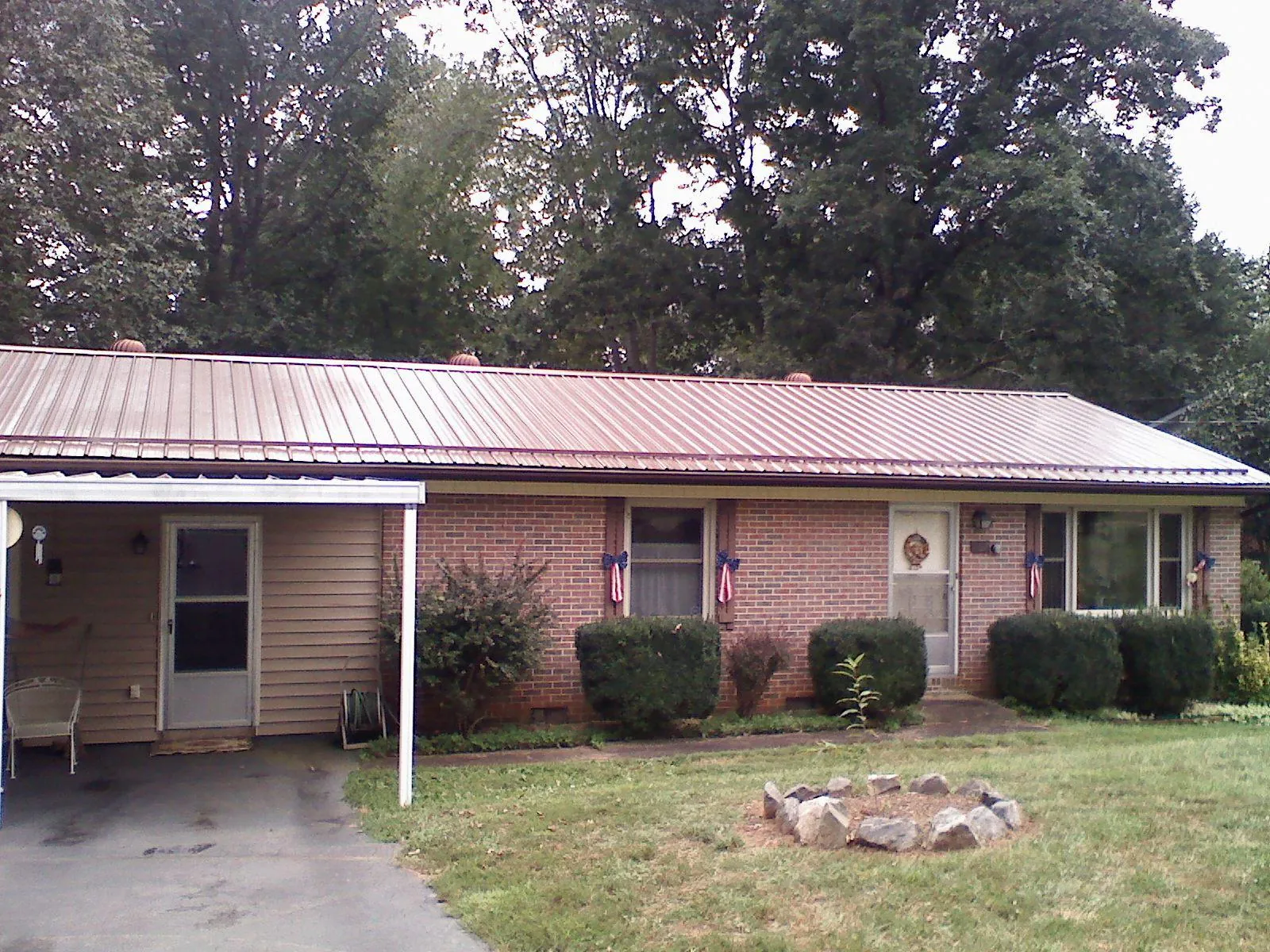Bronze metal roof and carport on a brick ranch home — Roof Repair work by our crew in Marlinton