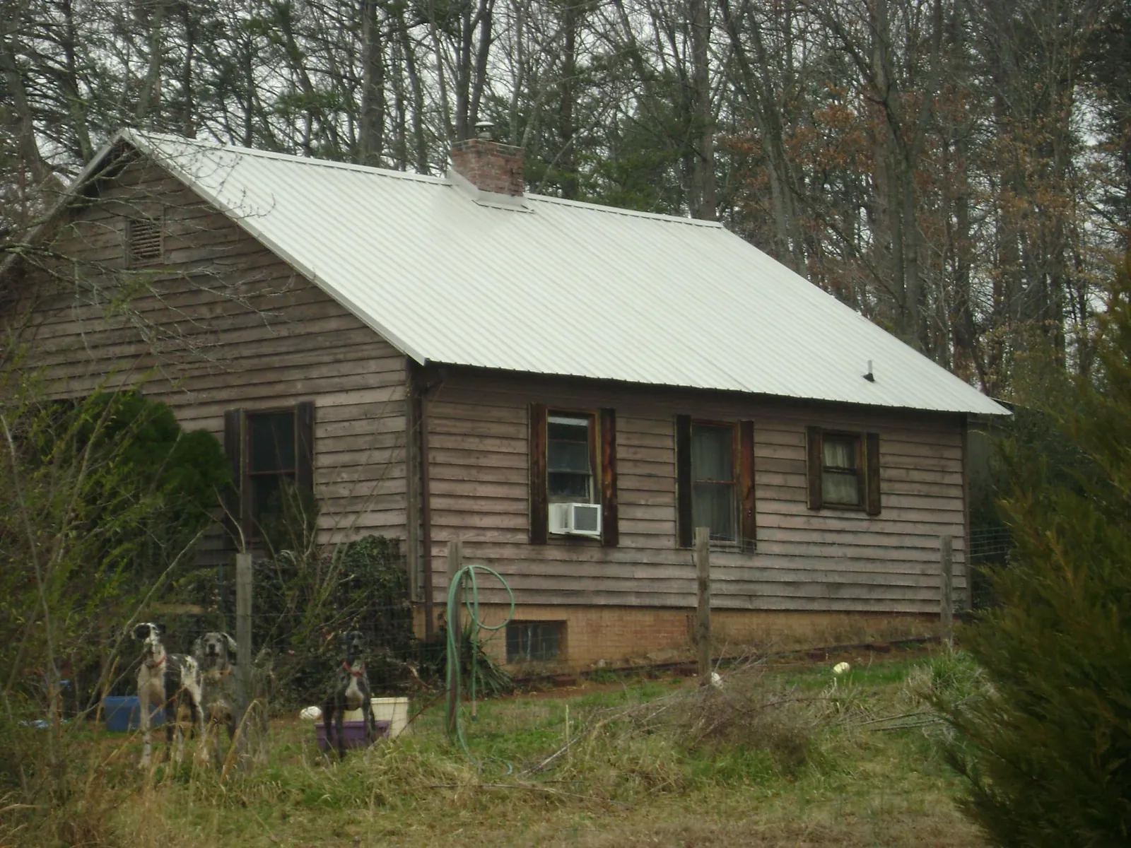 White metal roof on an old wood sided farmhouse, from a Metal Roof Installation job in Marlinton